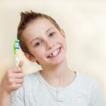 chłopiec trzyma szczoteczkę do zębów