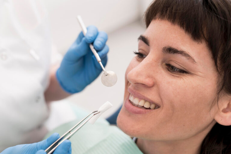 Dentysta trzyma implant zębowy przed twarzą pacjenta