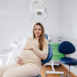 kobieta w ciąży siedząca na fotelu dentystycznym