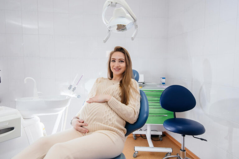 kobieta w ciąży siedząca na fotelu dentystycznym